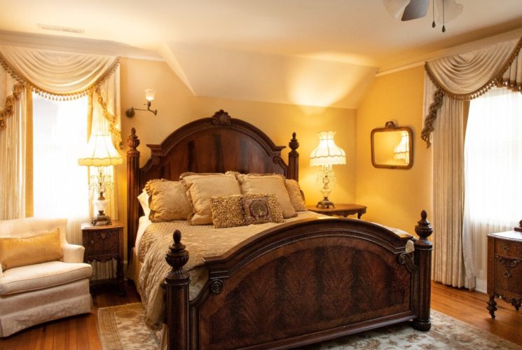 A spacious bedroom in shades of ivory and gold with a plush, king-size bed