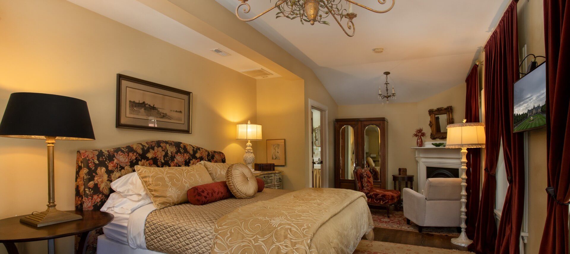 Bedroom with plush king-size bed, gas fireplace and sitting chairs