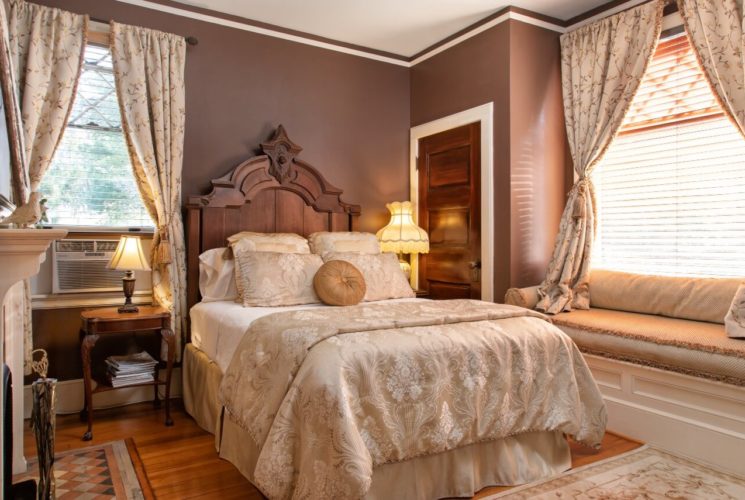 Romantic bedroom with queen bed, gas fireplace and window seat with plush cushions